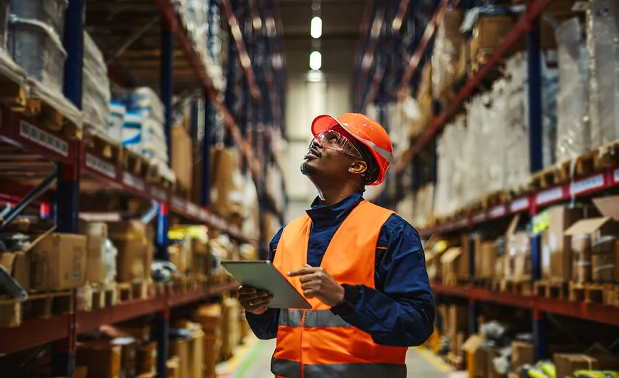A man in an orange vest check his inventory A man in an orange vest check his inventory