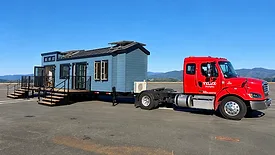 red semi truck hauling a tiny home