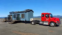 Red Semi-Truck Hauling a Tiny Home.png red semi truck hauling a tiny home